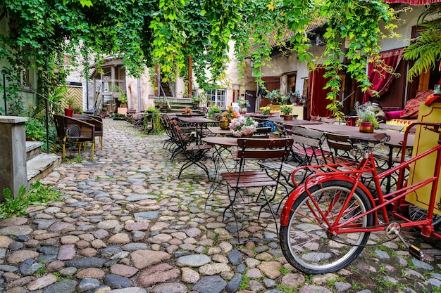 Lindo recanto com ambiente retrô com mesas, cadeiras e uma bicicleta velha.