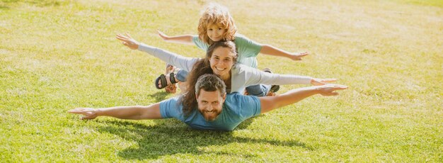 Lindo retrato familiar madre padre e hijo hijo divirtiéndose al aire libre en el panorama de la pancarta del parque de verano