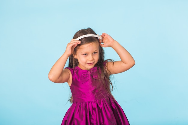 Lindo retrato de niña alegre, aislado en azul