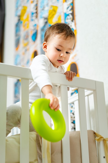 Lindo retrato de niño feliz niño juguetón en la cama jugando