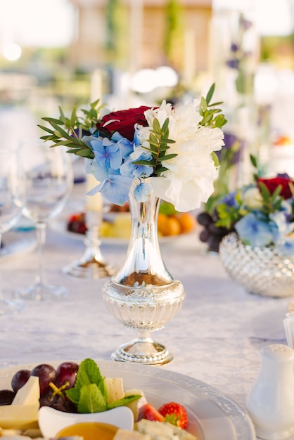 Lindo vaso de prata com um buquê de flores na decoração da mesa de casamento e casamento, aniversário, casa