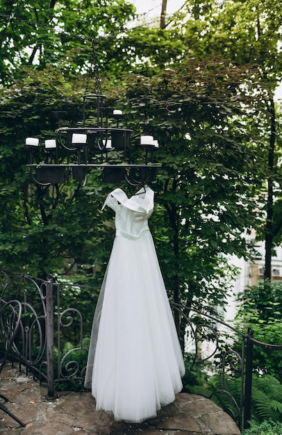 Lindo vestido de noiva branco e sapatos para a noiva pesam perto da cama A beleza de um vestido de noiva para casamento Roupa de festa de renda feminina