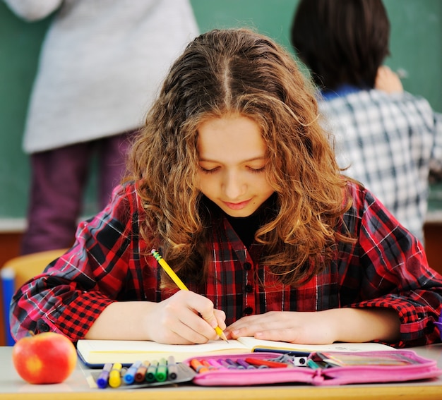 Lindos adorables escolares en el aula con actividades educativas