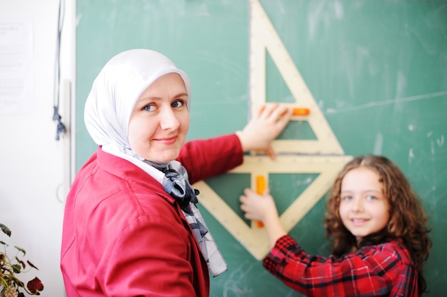 Lindos adorables escolares en el aula con actividades educativas