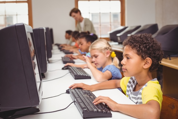 Foto lindos alumnos en clase de informática con el profesor