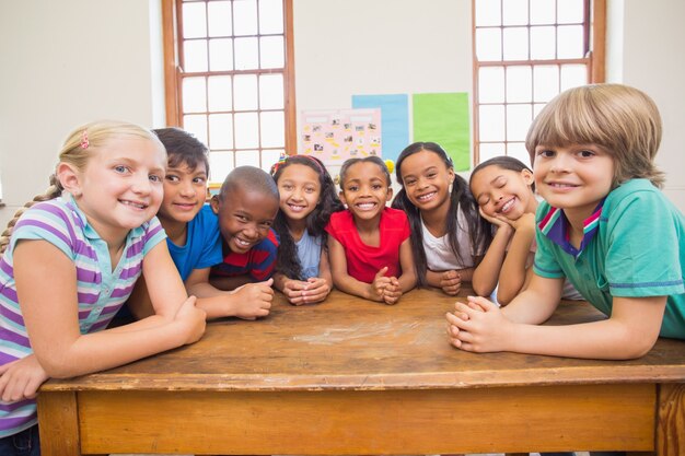 Lindos alumnos sonriendo a la cámara en el aula