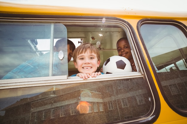 Lindos alumnos sonriendo a la cámara en el autobús escolar