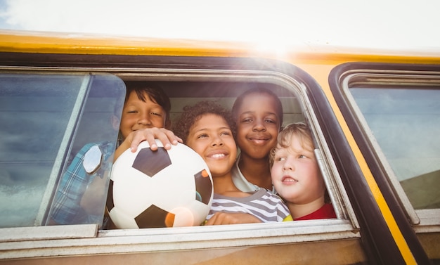 Lindos alumnos sonriendo a la cámara en el autobús escolar