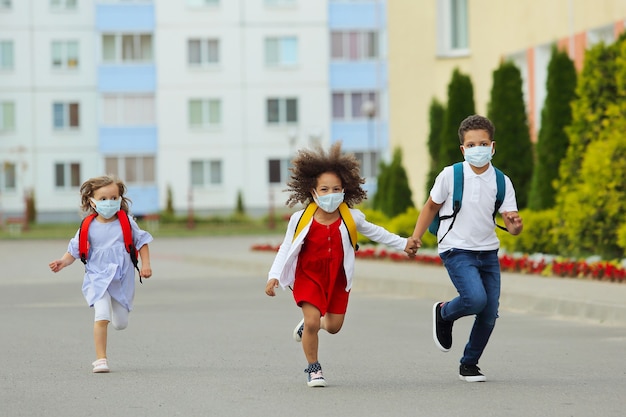 Lindos estudiantes blancos y negros están corriendo de regreso a la escuela.