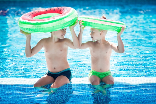 Lindos niños cerca de la piscina. Niños divirtiéndose en verano.