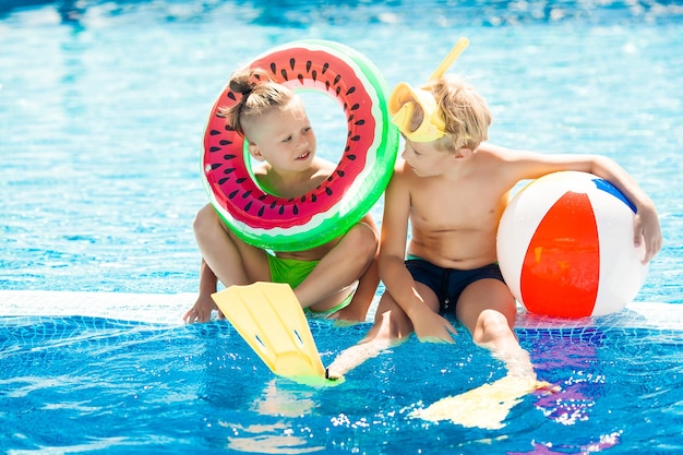 Lindos niños cerca de la piscina. Niños divirtiéndose en verano.