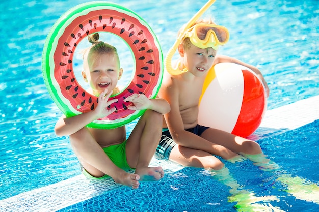 Lindos niños cerca de la piscina. Niños divirtiéndose en verano.