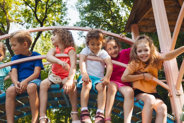 Los lindos niños descansan en el patio de recreo en verano.