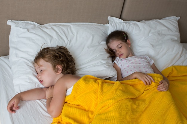 lindos niños durmiendo en la cama