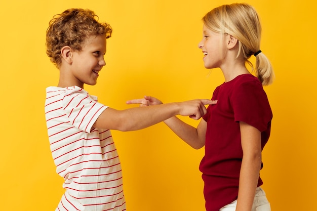 Lindos niños en edad preescolar abrazando entretenimiento infantil de moda sobre fondo de color