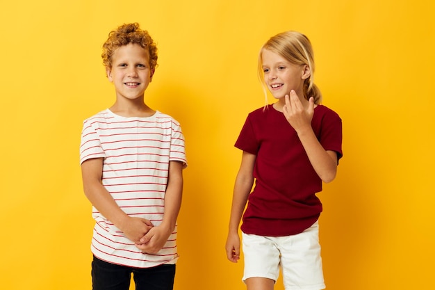 Lindos niños con estilo caricias moda infantil entretenimiento fondo amarillo