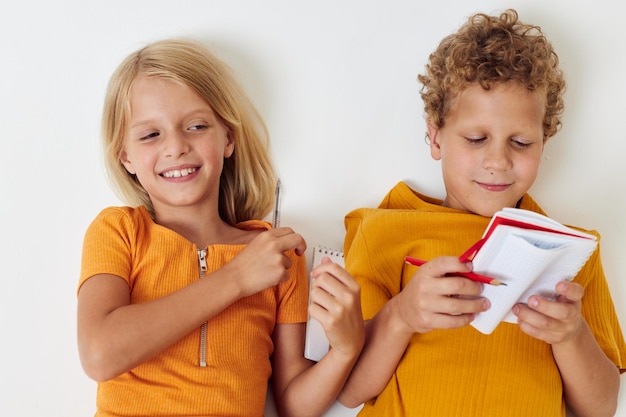 Lindos niños con estilo dibujando en cuadernos tirados en el piso estilo de vida infantil inalterado