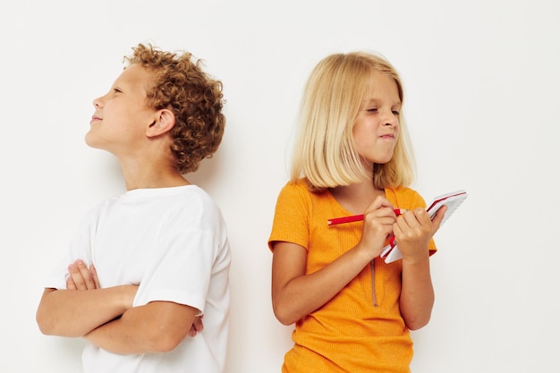 Lindos niños con estilo se paran junto al bloc de notas dibujo a lápiz emociones color fondo inalterado