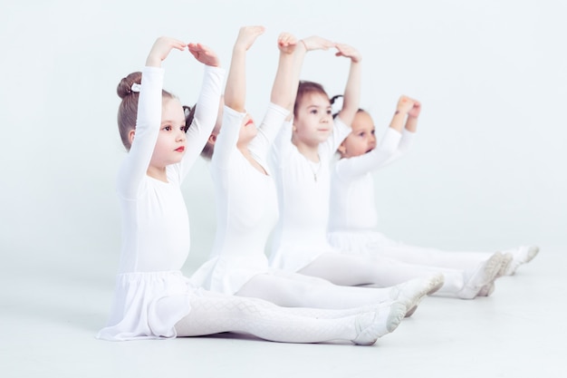 Lindos niños pequeños bailarines sobre fondo blanco danza coreografiada