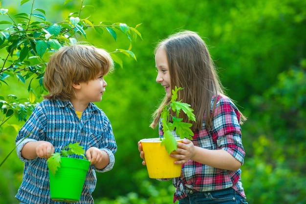 Lindos niños pequeños disfrutando en el concepto de ecología de la granja jardinería infantil con niños