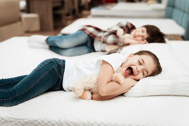 Lindos niños pequeños durmiendo en un colchón en la tienda