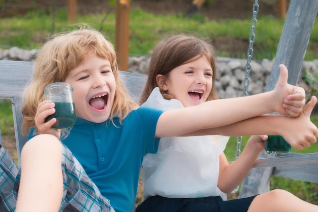 Lindos niños pequeños jugando al aire libre retrato de dos niños felices en el parque de primavera amor lindo