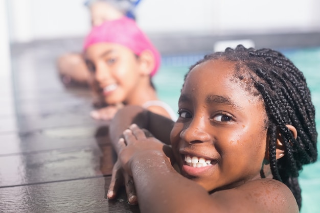 Lindos niños pequeños nadando en la piscina