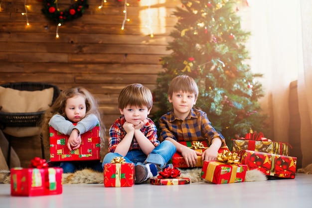 Lindos niños pequeños con regalos de Navidad