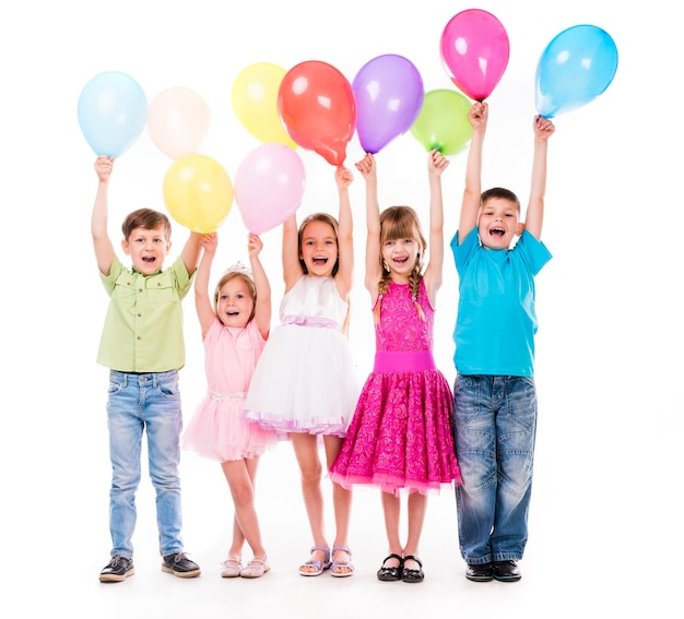 lindos niños riendo con las manos en alto y globos coloridos