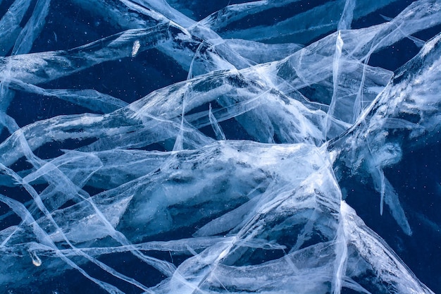 Lindos padrões de rachaduras em gelo azul transparente. A textura natural do gelo. Horizontal.