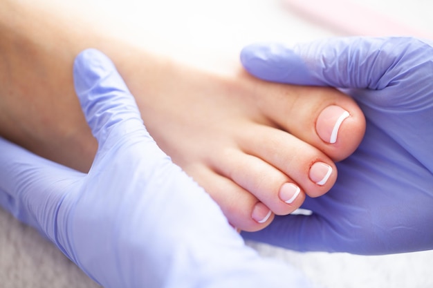 Lindos pés femininos com pedicure no salão de beleza