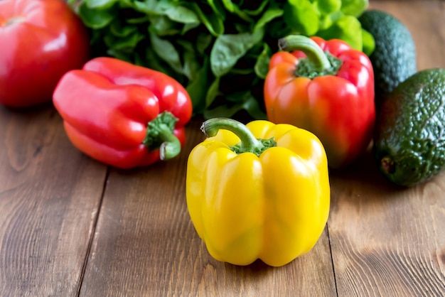 Lindos pimentões amarelos e vermelhos crus sobre fundo de madeira Salada Fechar Vegetais