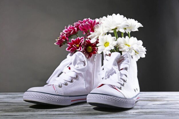 Lindos sapatos desportivos com flores dentro isoladas em branco
