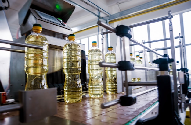 Línea de embotellado de aceite de girasol en botellas. Planta de producción de aceite vegetal. Alta tecnología.