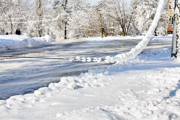 Línea de energía eléctrica colgando bajo el peso de la nieve