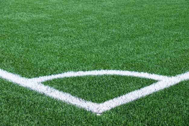 Línea de esquina blanca en el campo de fútbol verde