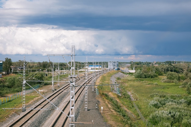 Línea de ferrocarril que se extiende hacia el horizonte sobre un fondo de cielo nublado