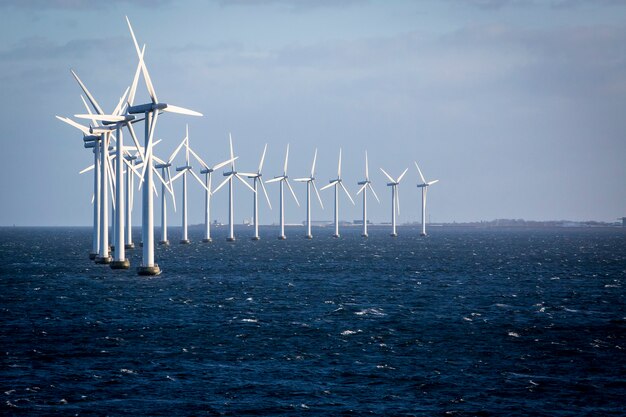 Una línea de molinos de viento en el océano.