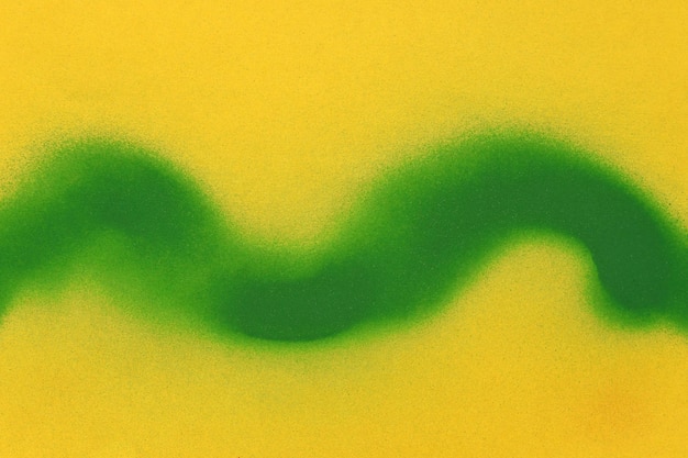 línea ondulada de pintura en aerosol verde sobre fondo de papel amarillo.