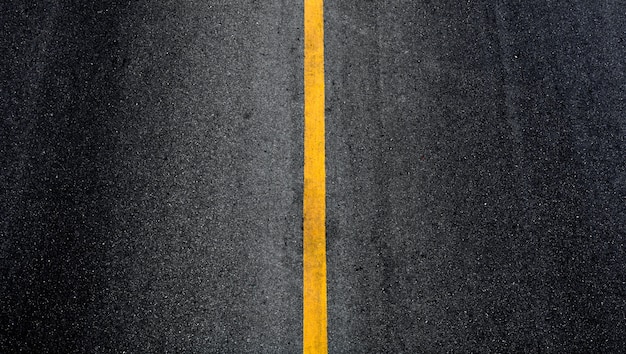 Línea de pintura amarilla sobre asfalto negro.