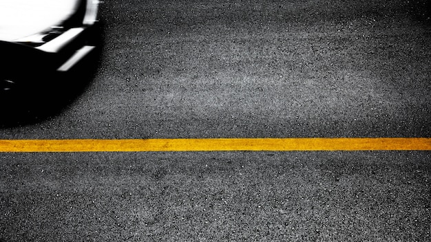 Línea de pintura amarilla sobre asfalto negro.