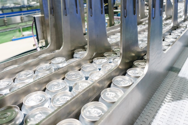 Línea transportadora con miles de latas de bebidas de aluminio en fábrica