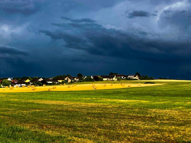 Foto líneas diagonales y balas de heno en el campo de alemania cielo oscuro antes de una tormenta un campo con