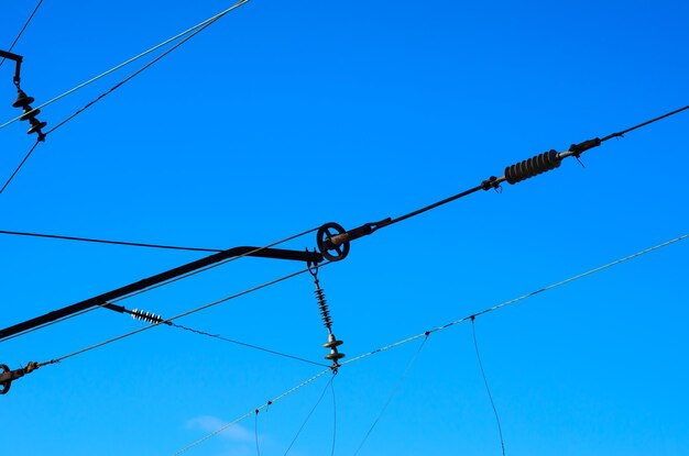 Líneas eléctricas aéreas de ferrocarril contra el cielo azul