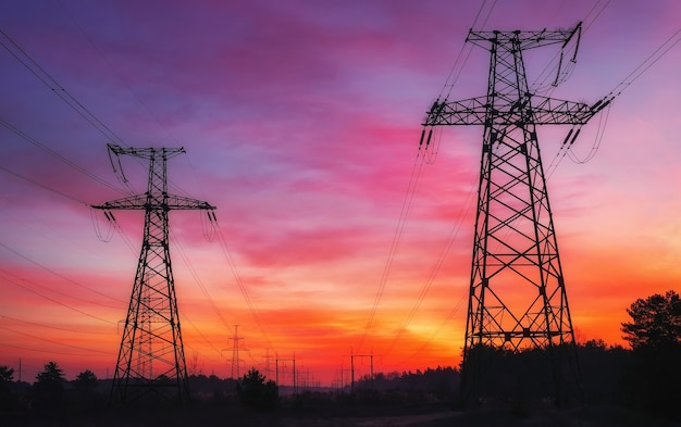 Foto líneas eléctricas de alto voltaje durante el ardiente amanecer