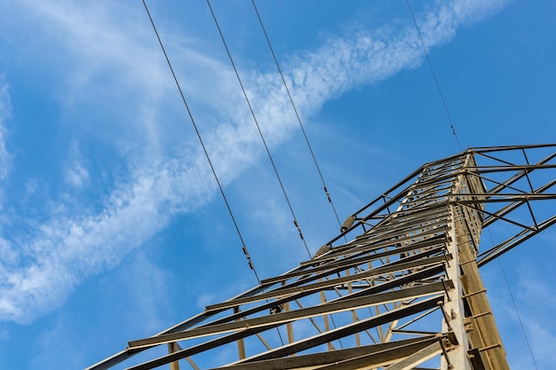 Líneas eléctricas de transmisión desde abajo sobre un cielo azul claro