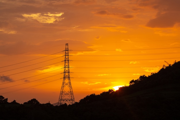 Líneas eléctricas de transmisión de electricidad al atardecer, torre de alta tensión.