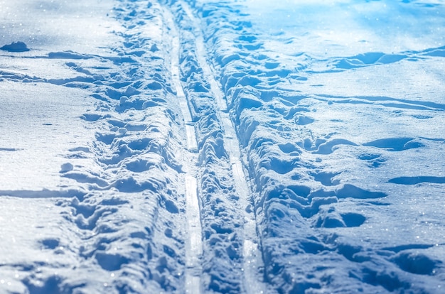 Líneas de nieve hechas con una máquina de nieve en una pista de esquí.