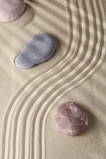 Líneas suaves en la arena y piedras redondas.