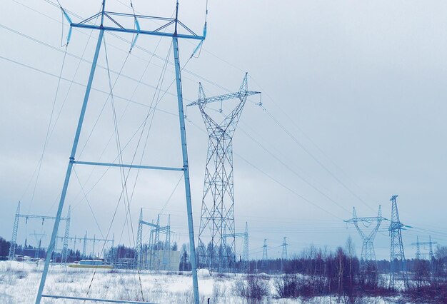 Líneas de transmisión eléctrica en la carretera nevada en invierno Rovaniemi, Laponia, Finlandia